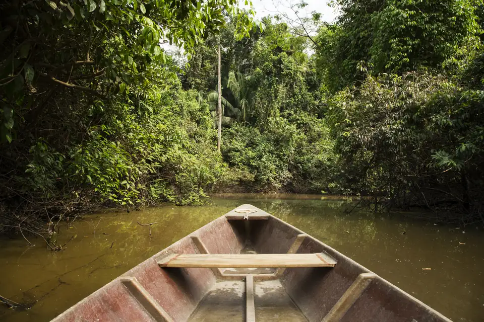 A canoe on an oxbow lake surrounded by forest at Hacienda Concepción